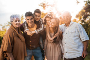 family with kids and grandparents smiling for fall family photo