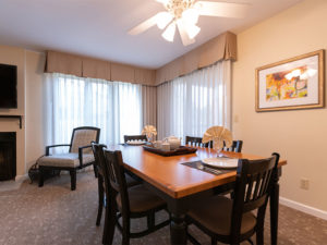 Dining room with brown and black dining table, six dining chairs and ceiling fan