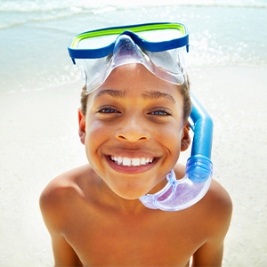 kid in snorkel gear at the beach
