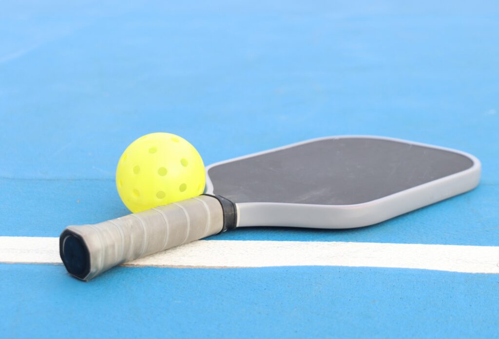 pickleball paddle and ball on the court